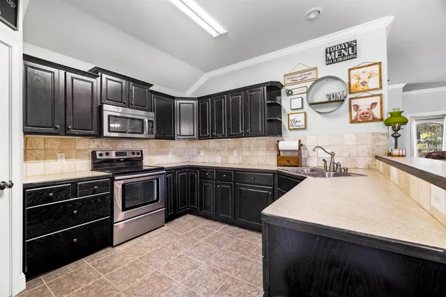 a kitchen with stainless steel appliances granite countertop wooden cabinets a stove top oven a sink and dishwasher