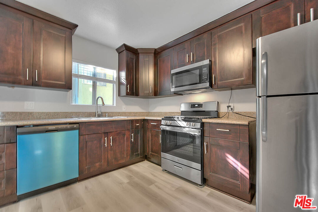 a kitchen with granite countertop stainless steel appliances and sink