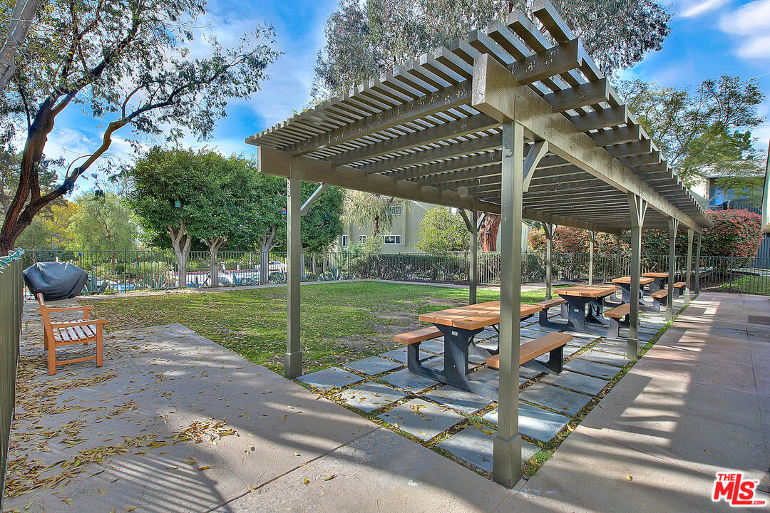 4822 Hollow Corner Road, Unit 177 Culver City, CA 90230 - Photo 38 of 39 a view of a patio with table and chairs potted plants with wooden floor and fence