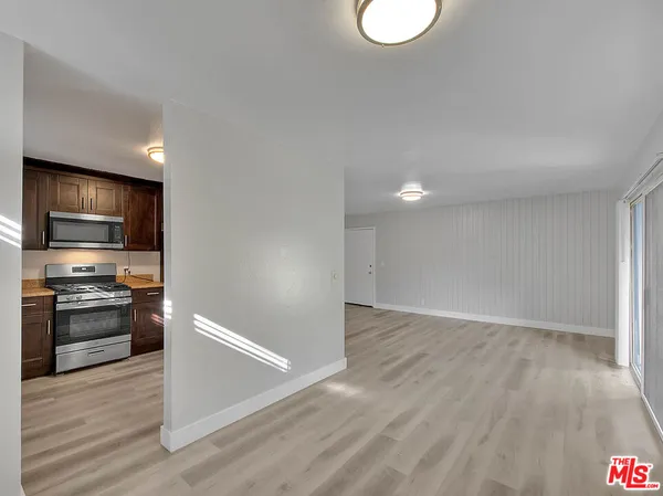 a view of a kitchen with a sink stove cabinets and empty room