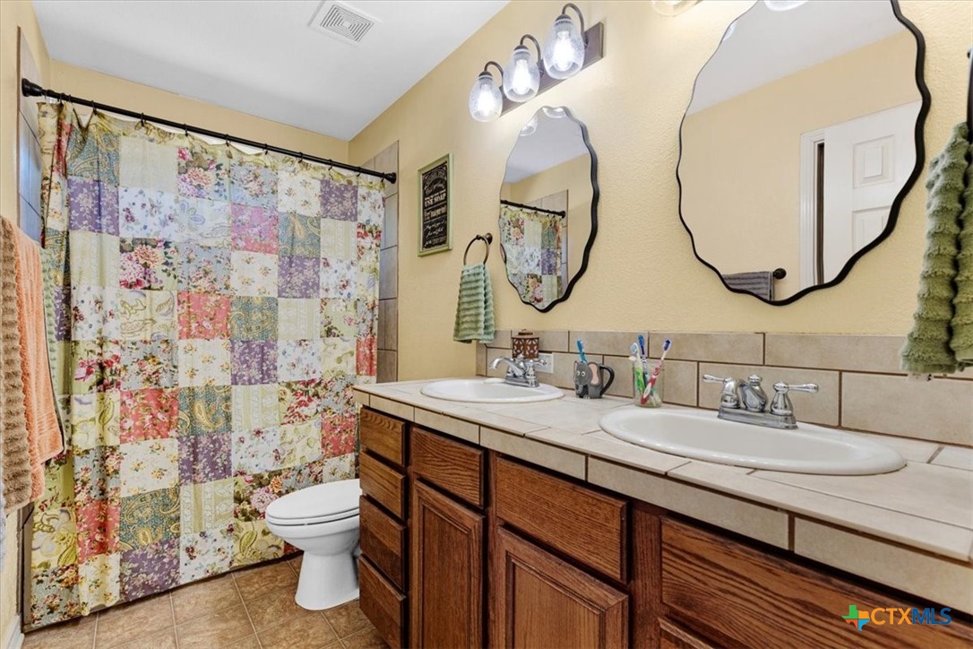 110 Sky Ranch Road Smithville, TX 78957 - Photo 20 of 31 a bathroom with a sink a toilet and a mirror