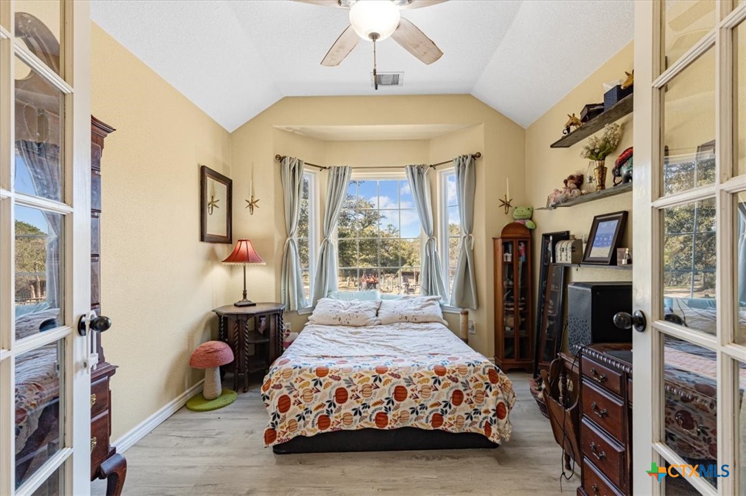110 Sky Ranch Road Smithville, TX 78957 - Photo 21 of 31 a bedroom with a bed bookshelf and a large window