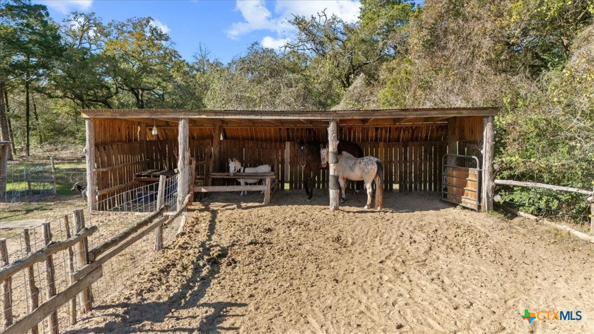 110 Sky Ranch Road Smithville, TX 78957 - Photo 5 of 31 a view of a patio with table and chairs a barbeque with wooden fence