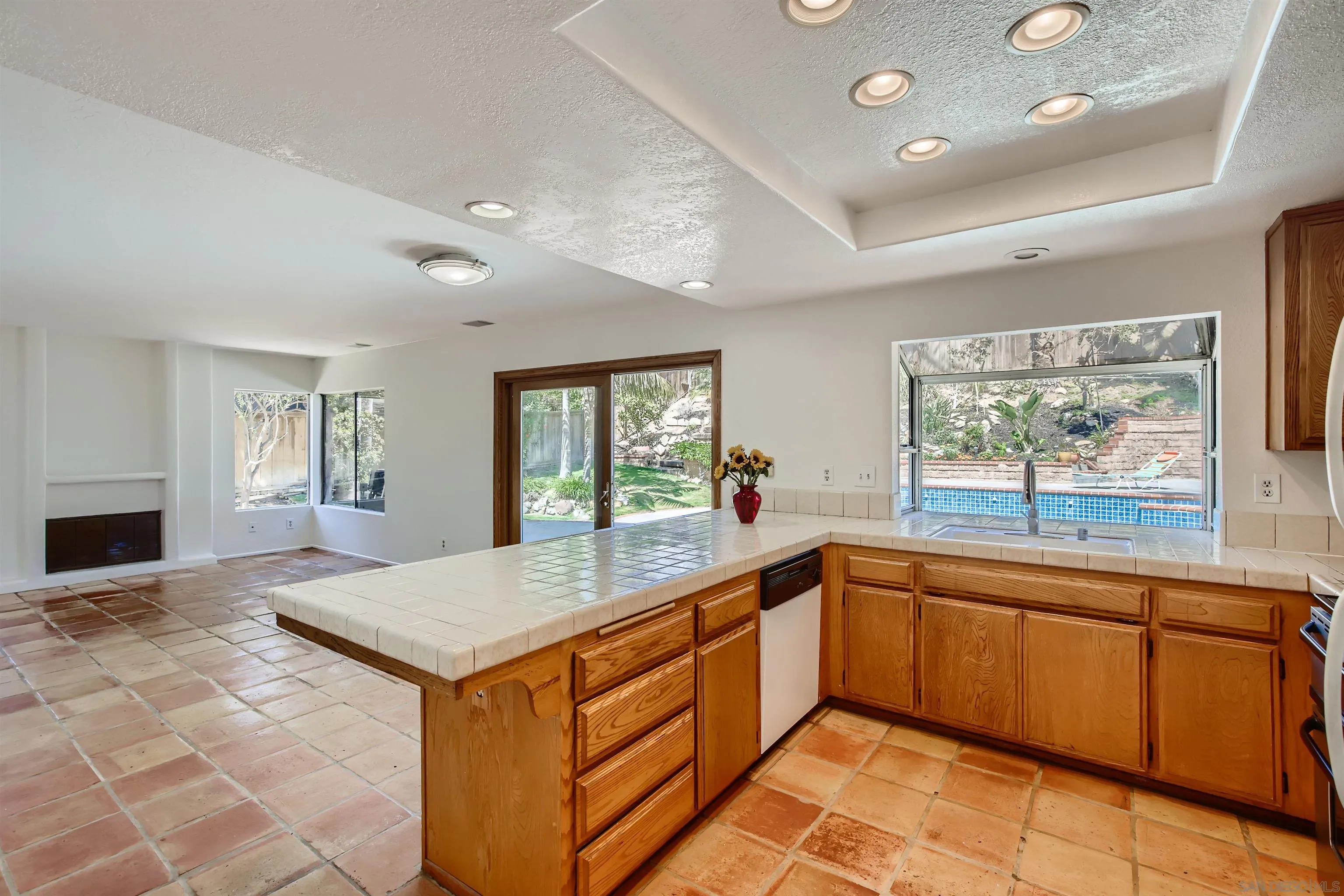 535 Gardendale Road Encinitas, CA 92024 - Photo 5 of 23 a large kitchen with kitchen island granite countertop a sink and white cabinets with wooden floor