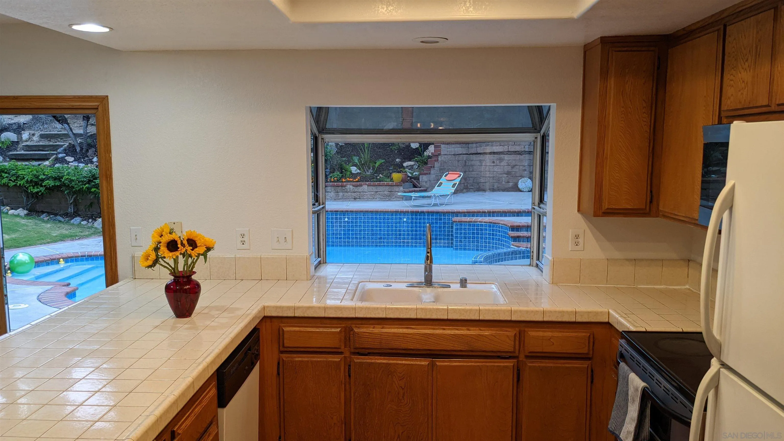 535 Gardendale Road Encinitas, CA 92024 - Photo 6 of 23 a kitchen with a sink and a refrigerator
