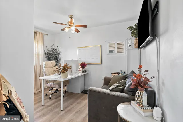 a living room with furniture a flat screen tv and a window