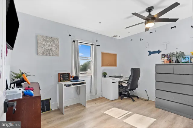 a view of a workspace with furniture and a window