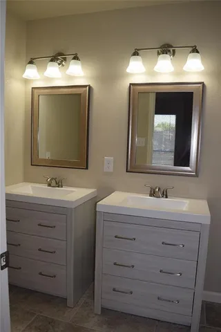 a bathroom with a double vanity sink and mirror