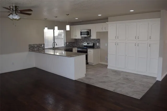 a kitchen with granite countertop stainless steel appliances and wooden cabinets