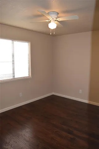 a view of a big room with wooden floor and windows