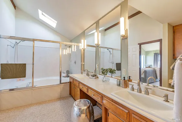 a bathroom with a double vanity sink a mirror and a bathtub