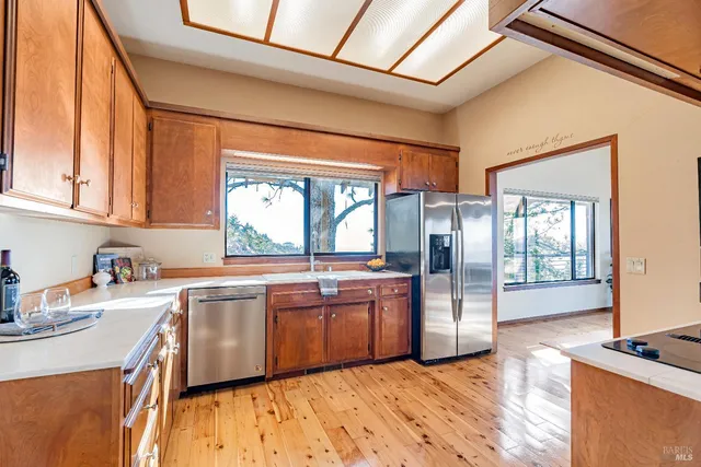 a kitchen with stainless steel appliances granite countertop a sink a stove and refrigerator