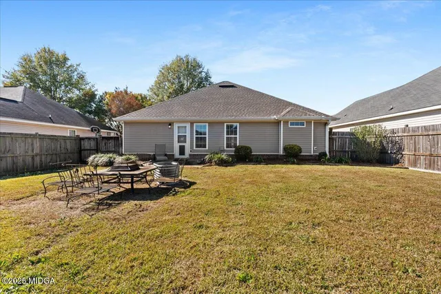 a view of a white house with a swimming pool and a yard