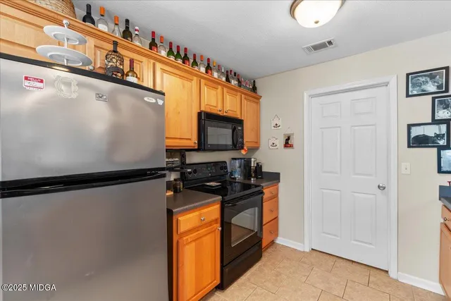 a kitchen with stainless steel appliances a refrigerator and a stove top oven