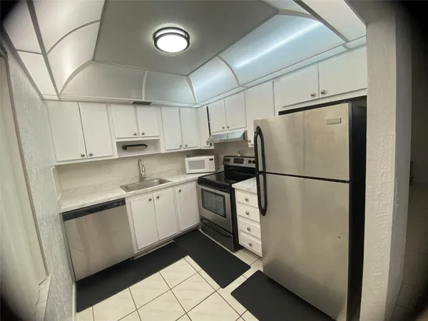 a kitchen with stainless steel appliances a refrigerator sink and cabinets