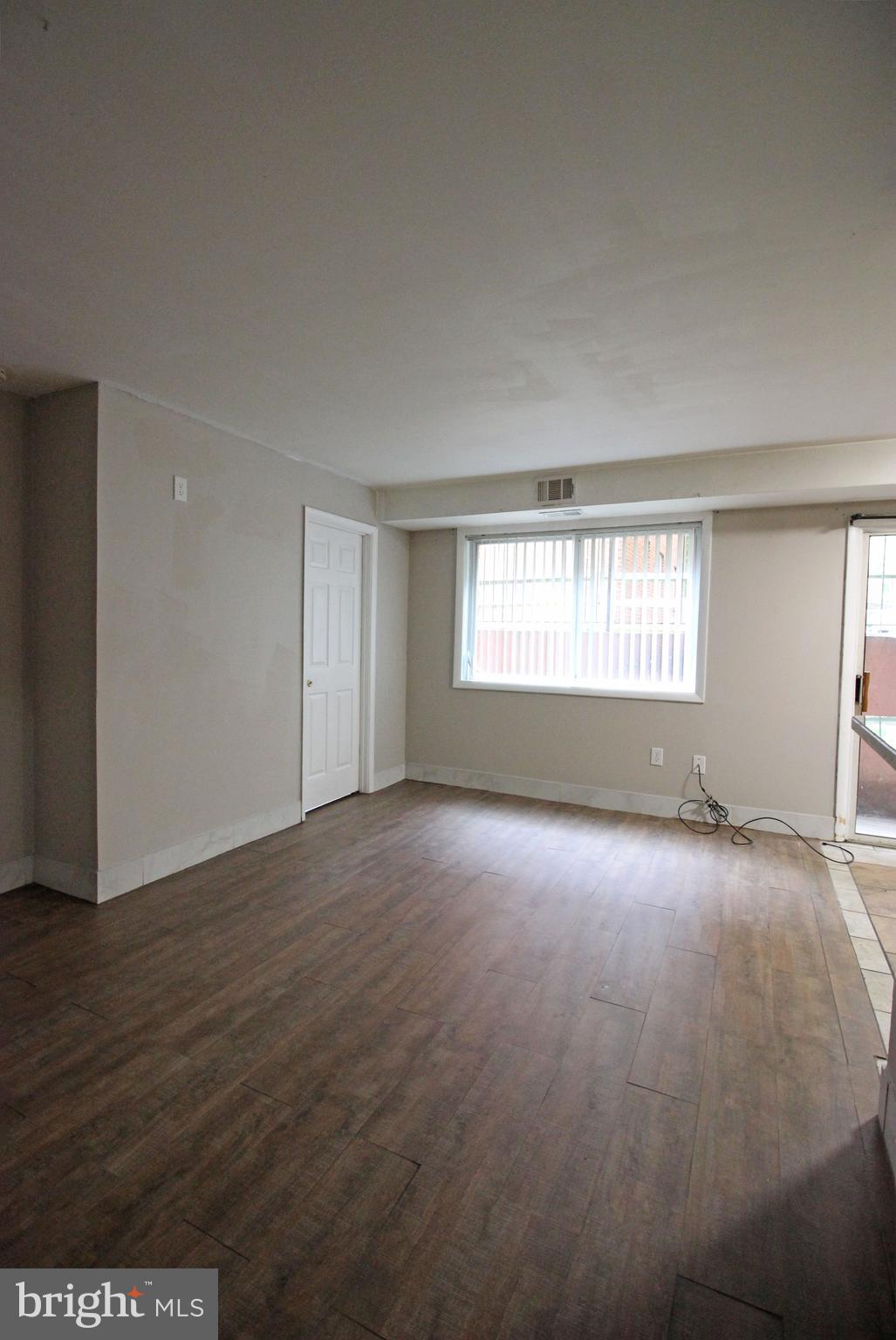 17 Water Street, Unit 30 Gaithersburg, MD 20877 - Photo 5 of 18 an empty room with wooden floor and windows