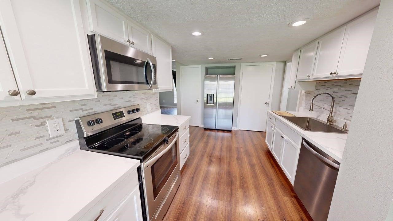 619 Cotter Drive Spring, TX 77373 - Photo 24 of 50 a kitchen with sink a microwave and cabinets