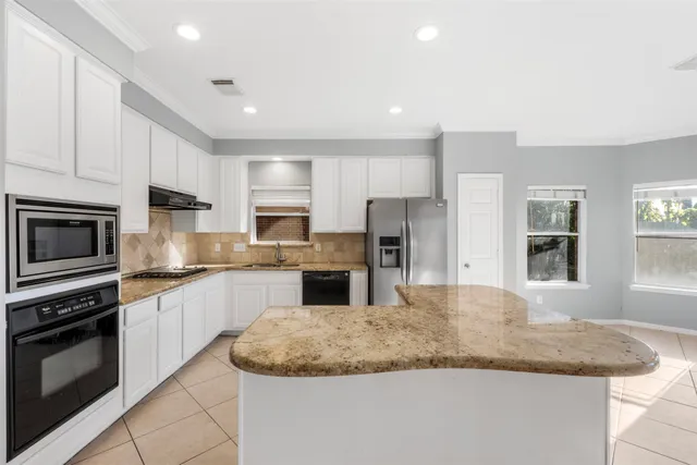 a kitchen with stainless steel appliances granite countertop a refrigerator sink and stove