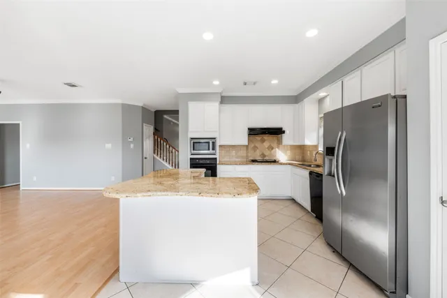 a kitchen with granite countertop white cabinets white appliances and sink
