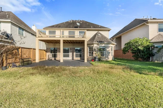 a view of a big house with a big yard and large trees