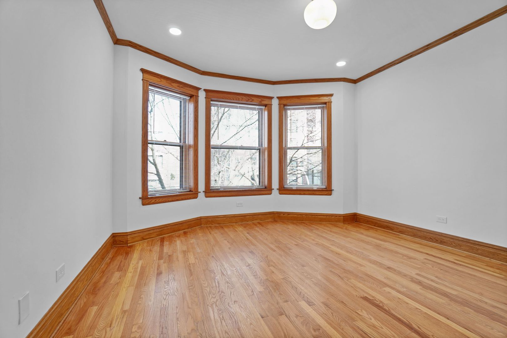 849 West Grace Street, Unit 2 Chicago, IL 60613 - Photo 3 of 19 an empty room with wooden floor and windows