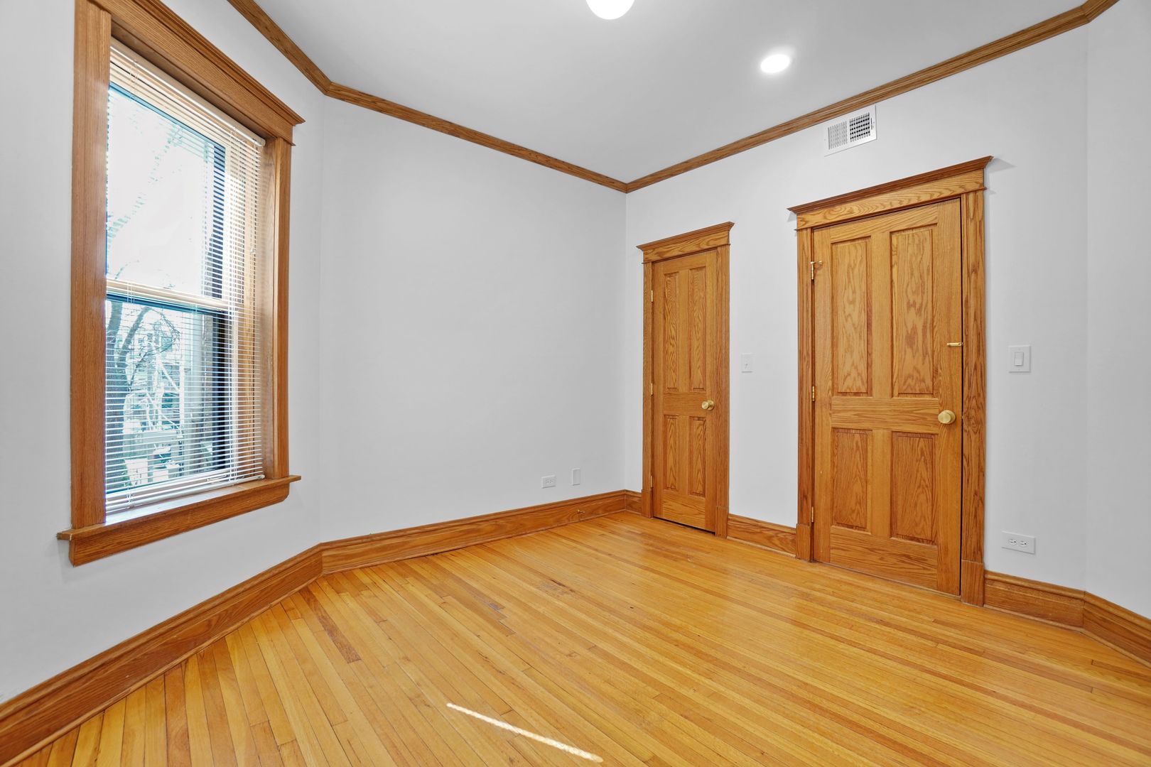 849 West Grace Street, Unit 2 Chicago, IL 60613 - Photo 8 of 19 a view of an empty room with wooden floor and a window