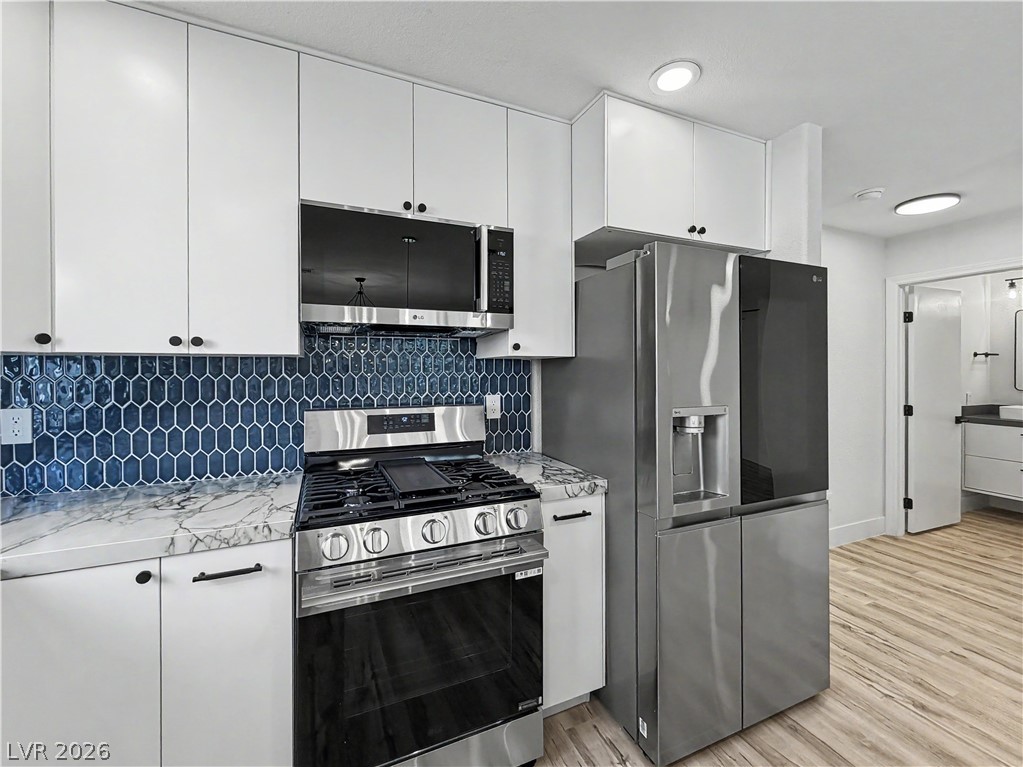8977 Paige Rene Court Las Vegas, NV 89117 - Photo 10 of 31 A well-appointed kitchen features modern appliances and elegant marble countertops, perfect for culinary endeavors.