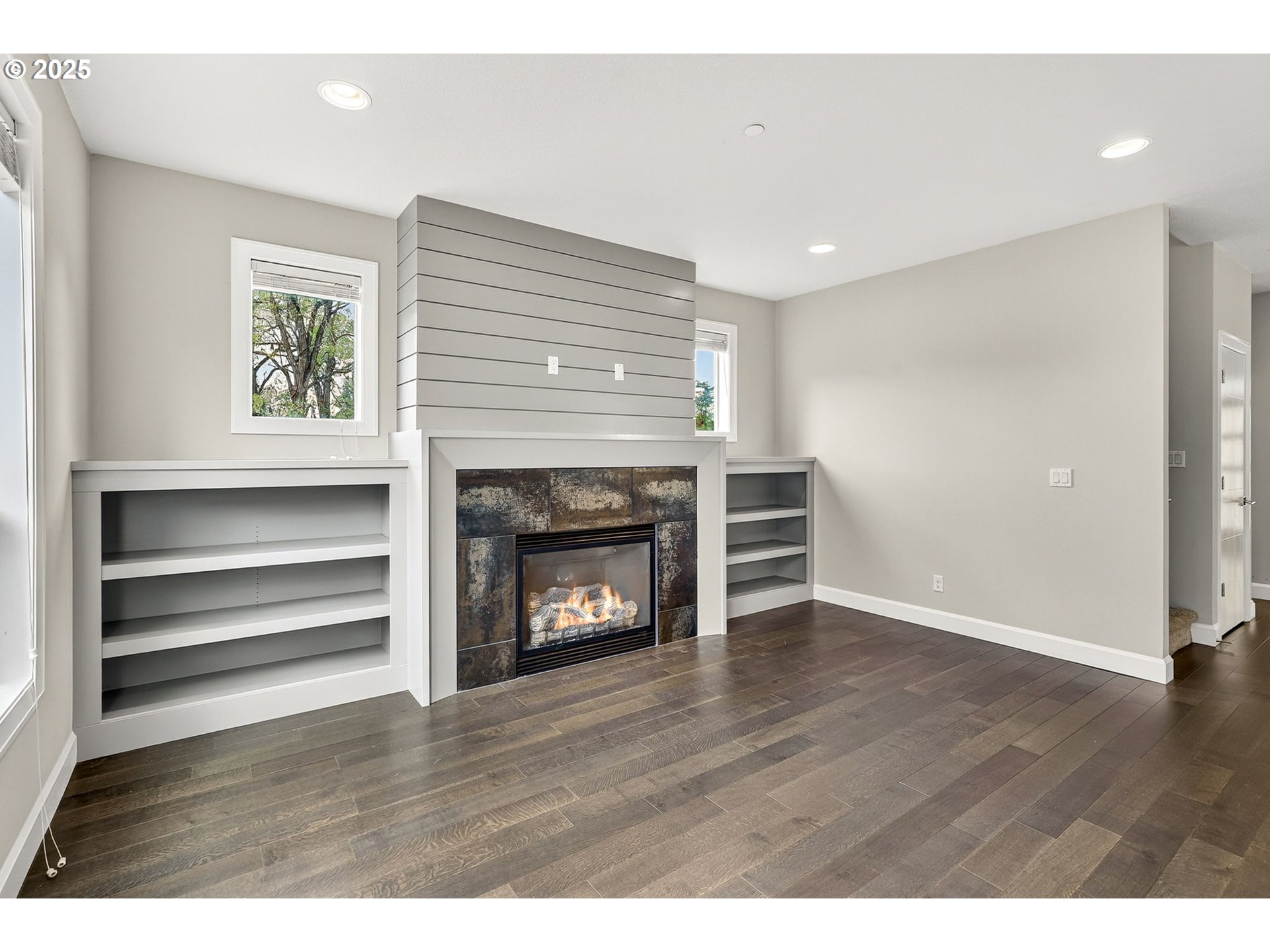 7830 Southeast Boise Court Portland, OR 97206 - Photo 22 of 48 a view of an empty room with wooden floor fireplace and a window