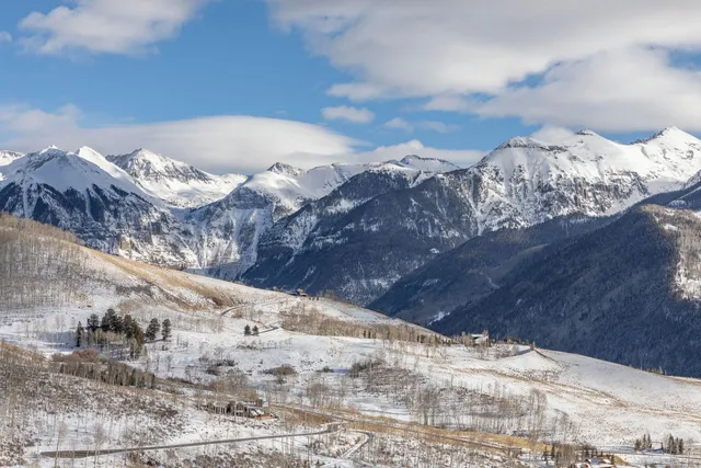 a view of a dry yard covered with snow in the background