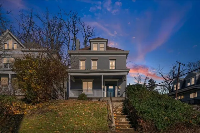 a view of a big house with large tree and a big yard