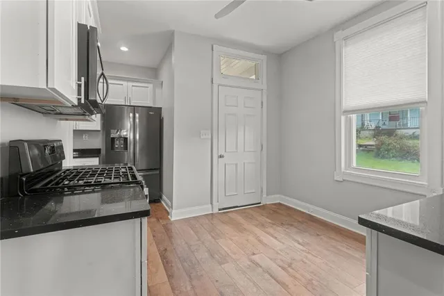 a kitchen with stainless steel appliances granite countertop a refrigerator and a stove top oven