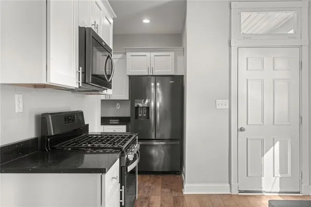 a kitchen with stainless steel appliances granite countertop a refrigerator stove and cabinets