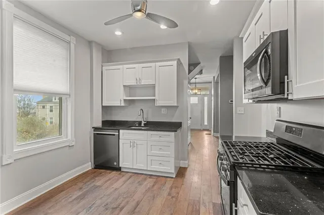 a kitchen with stainless steel appliances granite countertop a stove a sink and a refrigerator