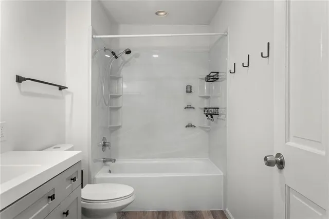 a bathroom with a bathtub shower sink vanity and toilet