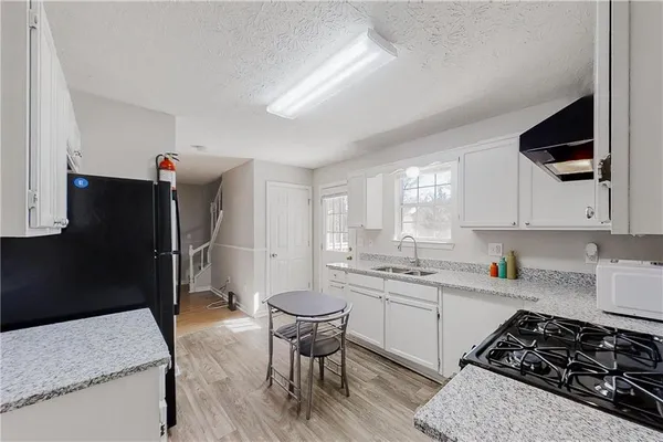 a kitchen with a stove a sink and a refrigerator