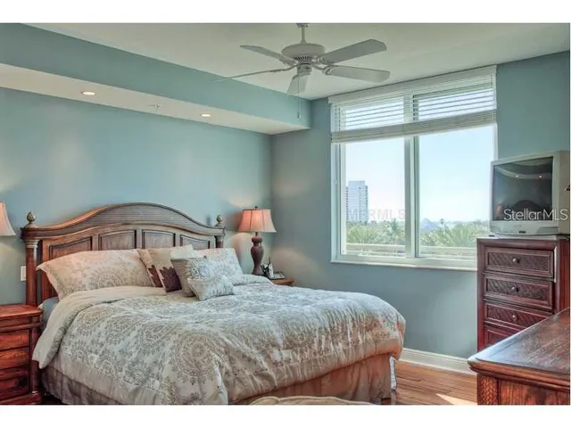 a bedroom with a bed and a flat tv screen on dresser