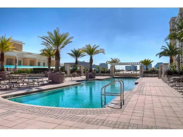a view of a swimming pool with tables and chairs