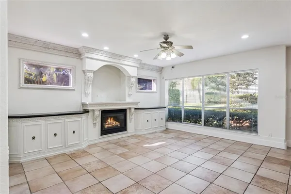 a view of an empty room with a window and a ceiling fan