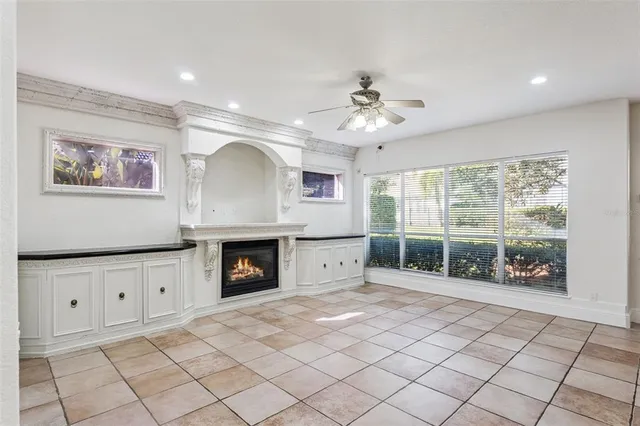 a view of an empty room with a window and a ceiling fan