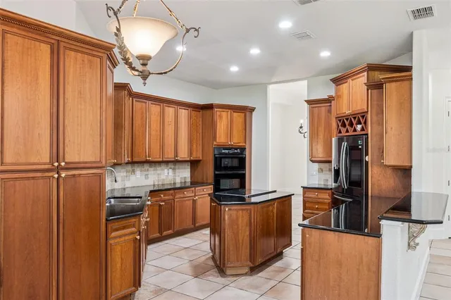 a kitchen with granite countertop a stove sink and cabinets