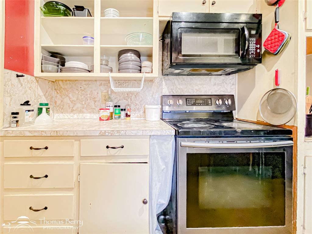 1029 Northwest 3rd Street Hamlin, TX 79520 - Photo 12 of 35 a kitchen with a stove and a microwave