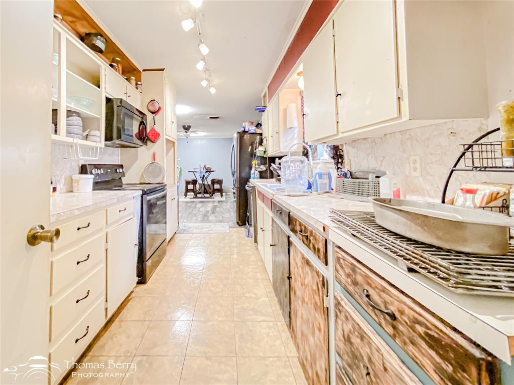 1029 Northwest 3rd Street Hamlin, TX 79520 - Photo 14 of 35 a large kitchen with stainless steel appliances granite countertop a stove and a sink