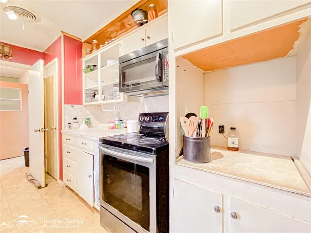 a kitchen with stainless steel appliances cabinets and a large window