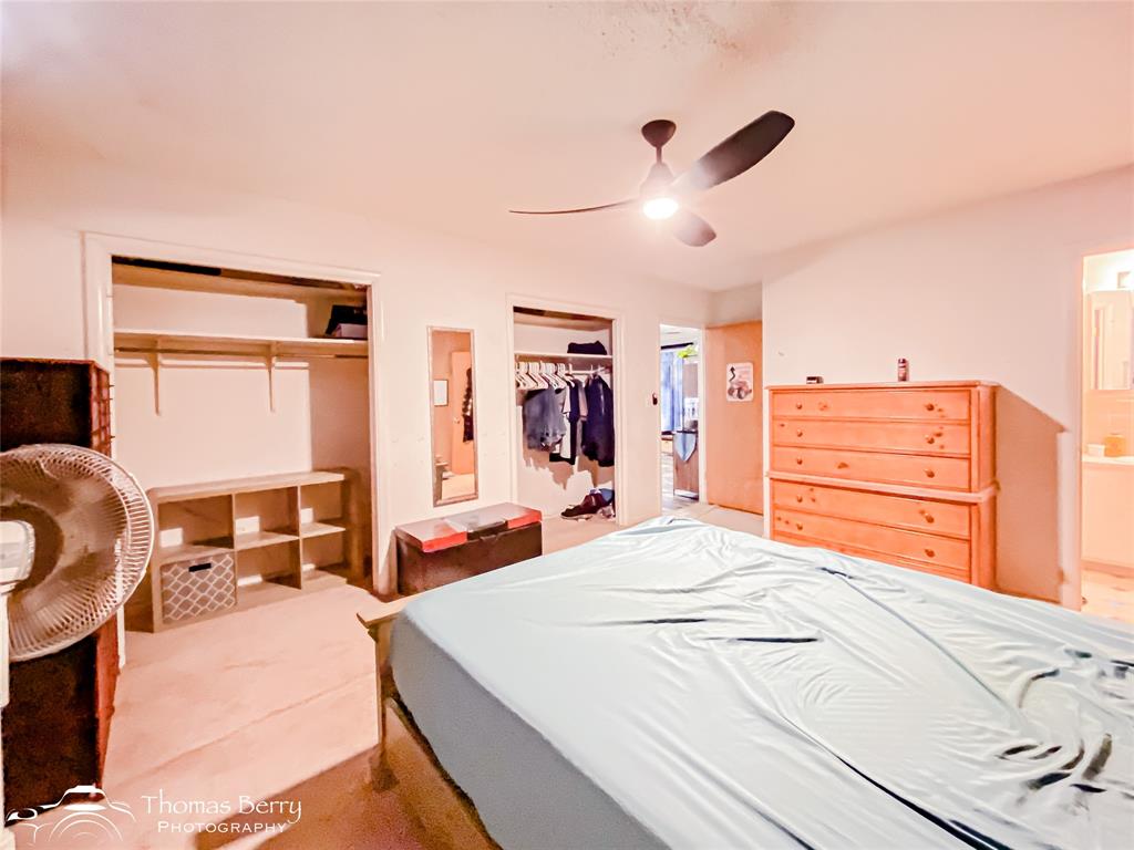 1029 Northwest 3rd Street Hamlin, TX 79520 - Photo 27 of 35 a bedroom with a large bed and a chandelier