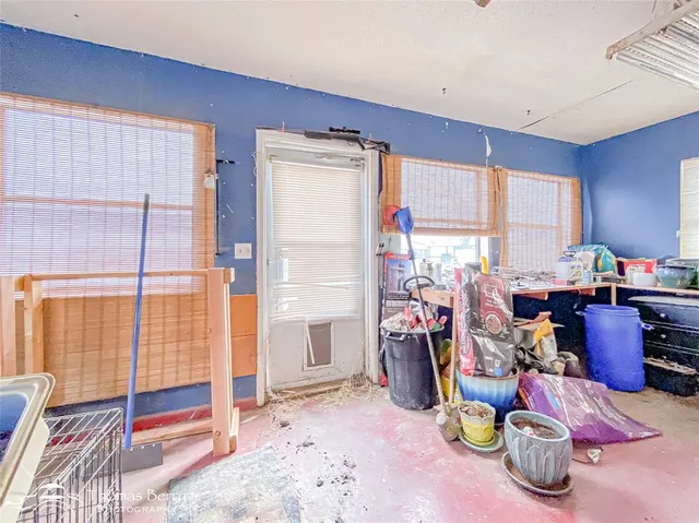a view of a large pool with lawn chairs under an umbrella