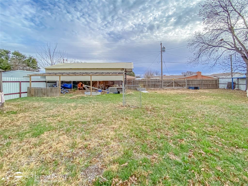 1029 Northwest 3rd Street Hamlin, TX 79520 - Photo 32 of 35 a view of a large pool with lawn chairs under an umbrella