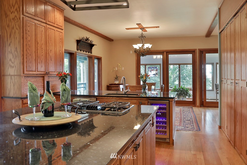 5741 Crow Haven Road Langley, WA 98260 - Photo 9 of 40 a kitchen with a table chairs stove and wooden floor