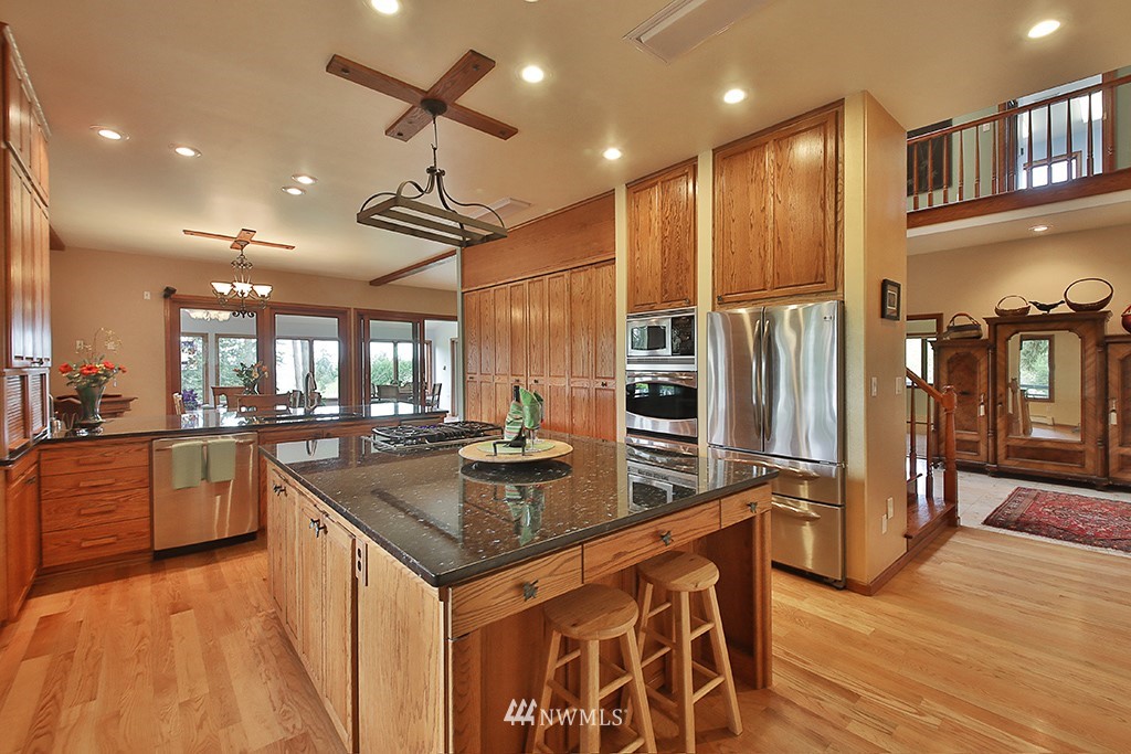 5741 Crow Haven Road Langley, WA 98260 - Photo 10 of 40 a kitchen with stainless steel appliances granite countertop a sink a stove and a refrigerator