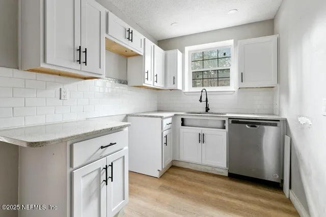 a kitchen with cabinets appliances a sink and a window