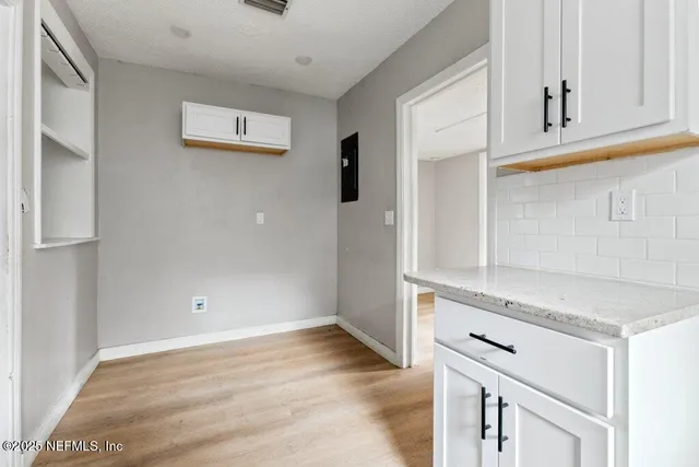 a view of a kitchen with wooden floor and cabinets